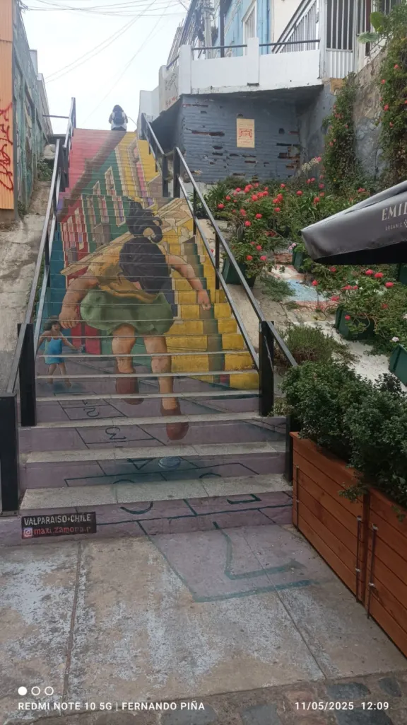 Escalera intervenida con el mural de un futbolista en un cerro de Valparaíso