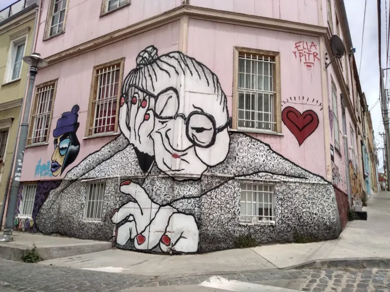 Mural de una anciana abrazando a un joven, obra del colectivo Inti, en una fachada del Cerro Concepción