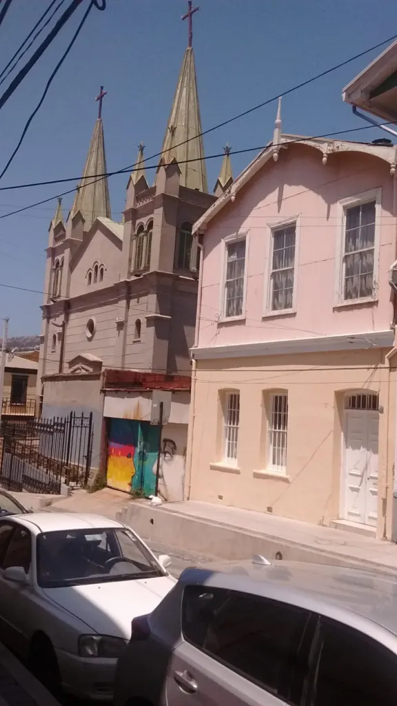 Mural con un bus violeta, flamingos y flora marina en un muro de Valparaíso