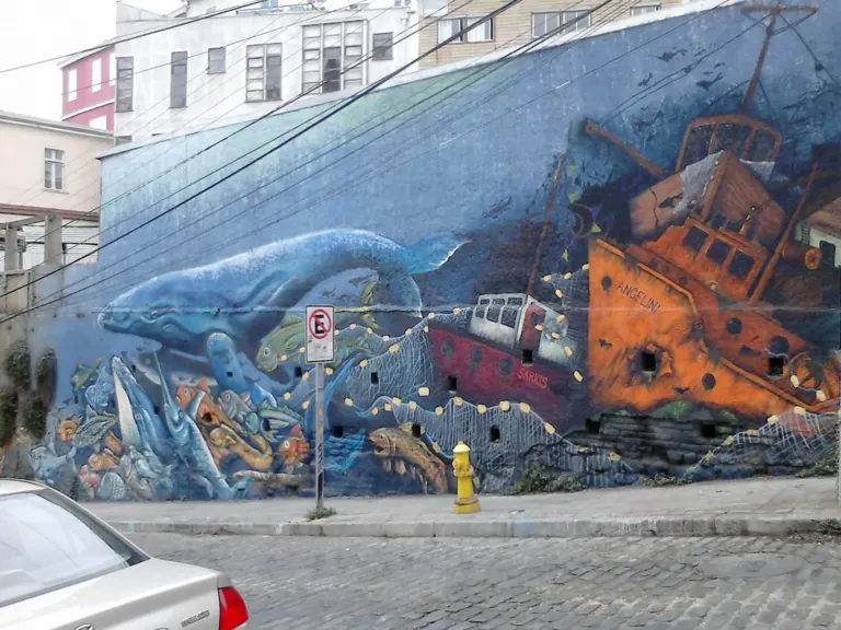 Mural de una ballena y un barco naufragado en una fachada de Valparaíso