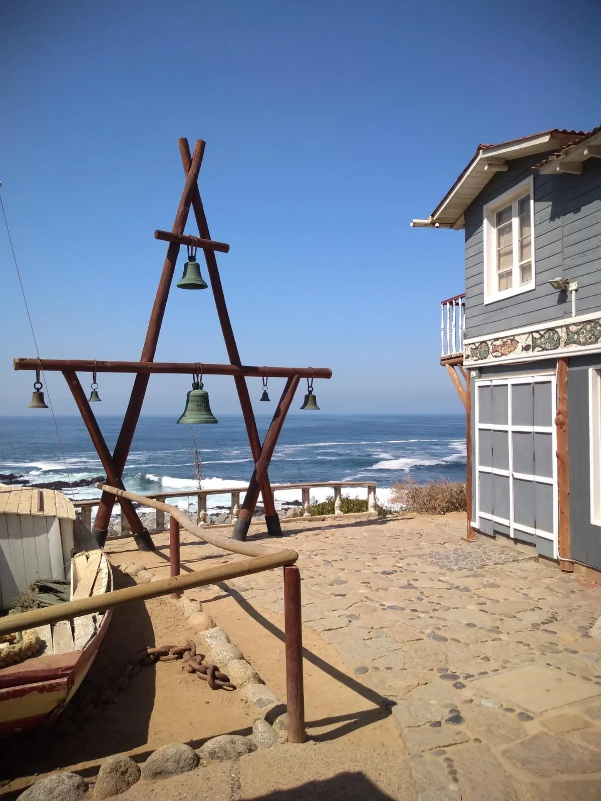 Estructura de madera con campanas frente al Pacífico junto a la casa azul del poeta en Isla Negra