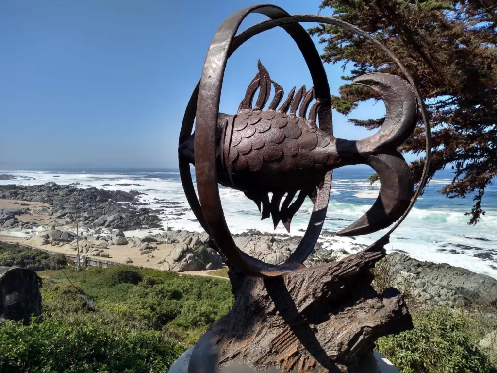 Fachada de piedra de la Casa Museo de Pablo Neruda en Isla Negra, con jardín de gazanias y margaritas en primer plano