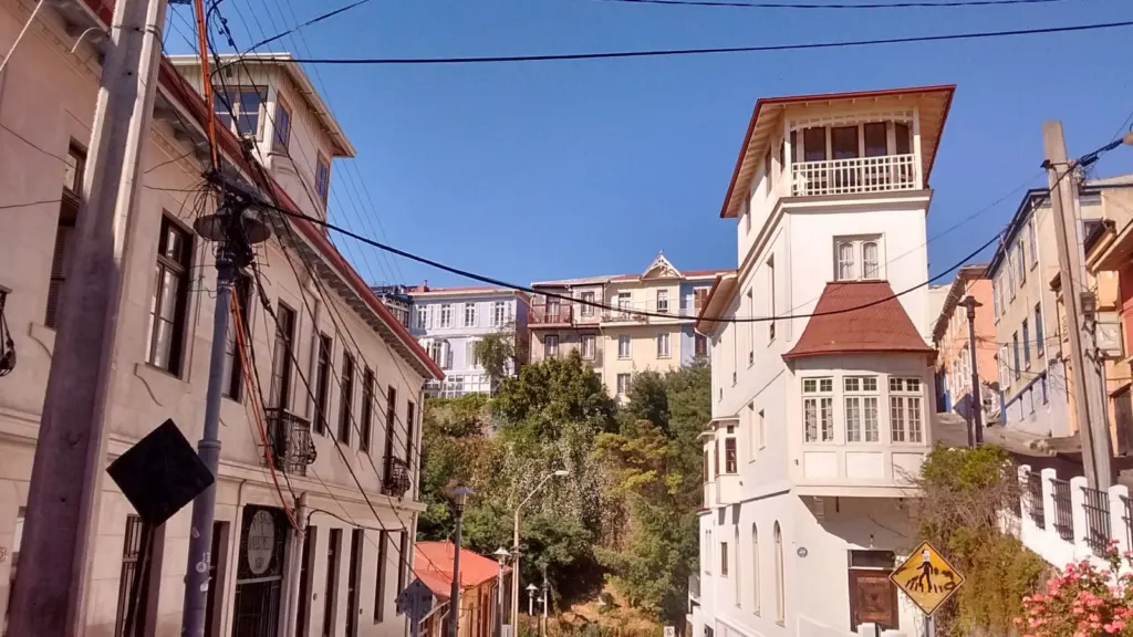 Casa blanca con torreón y fachadas de colores en una calle de los cerros de Valparaíso